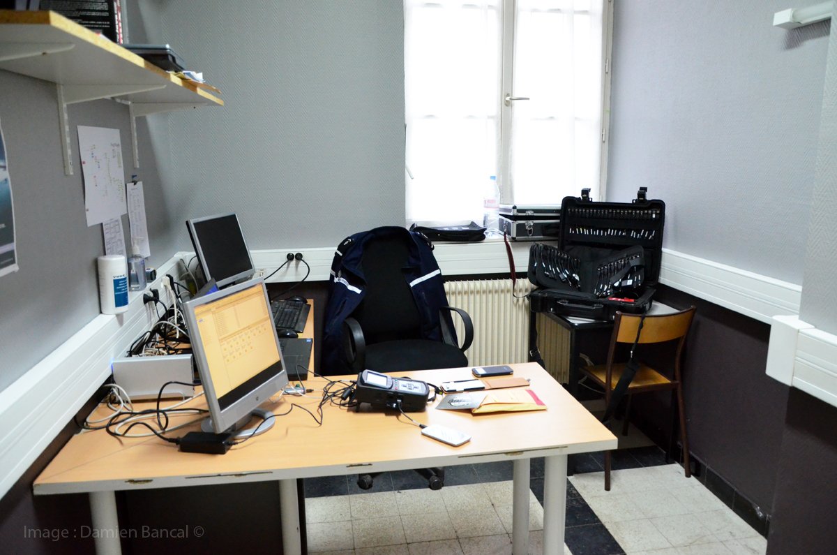 Un bureau, des ordinateurs et une valise capable de lire l'ensemble des téléphones portables du marché.